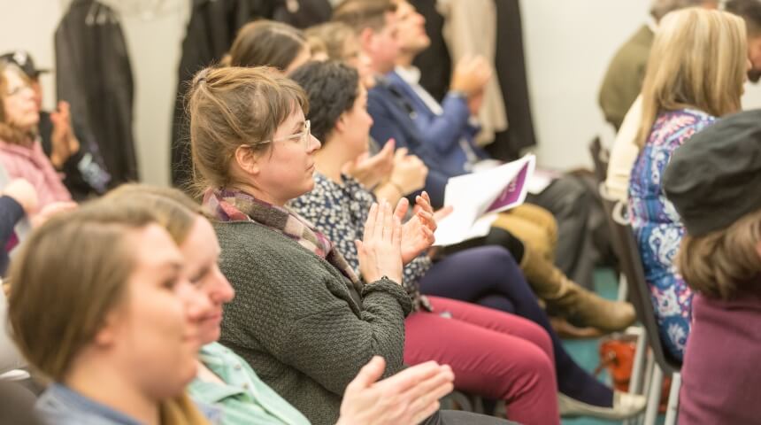 Close up of an audience clapping for a presenter
