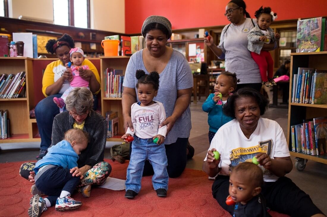 Caregivers and children enjoy using shaker eggs at a storytime at CLP- Homewood.