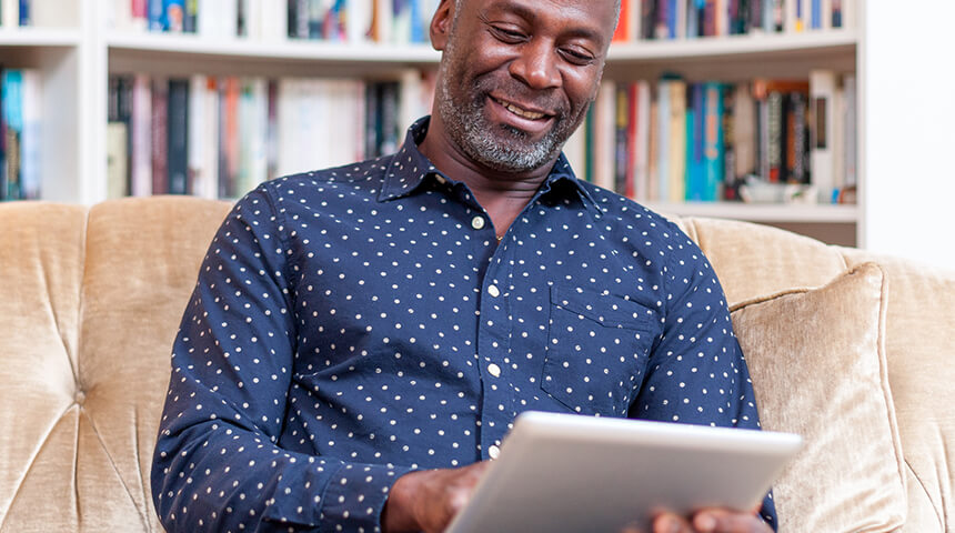 Person sitting on couch looking at tablet.