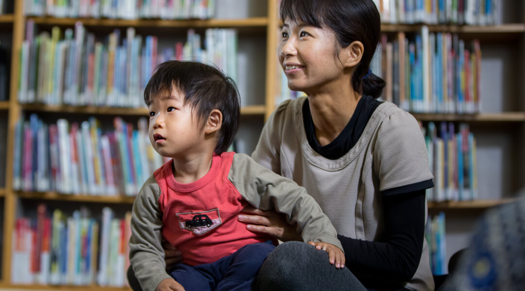 Toddler and caregiver listening to storytime.