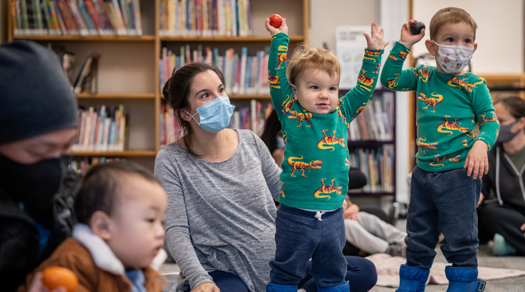Toddlers playing with shaker eggs during storytime.