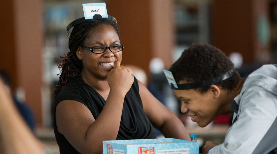 Smiling teens playing a matching game.