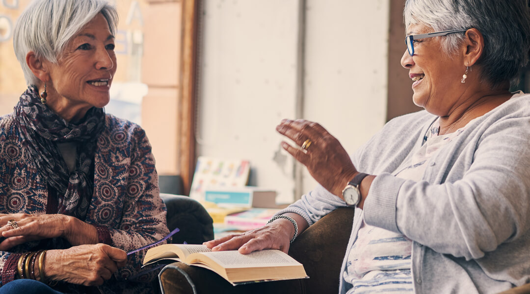 Two Adults Smile Over Book