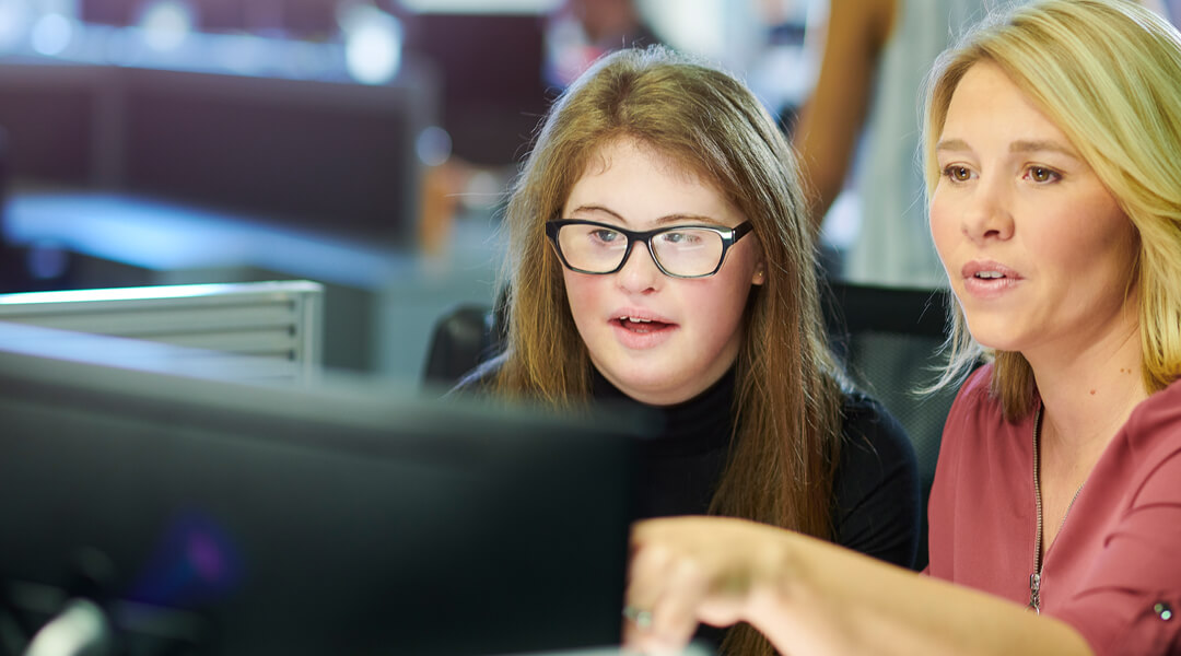 One person instructing another at computer
