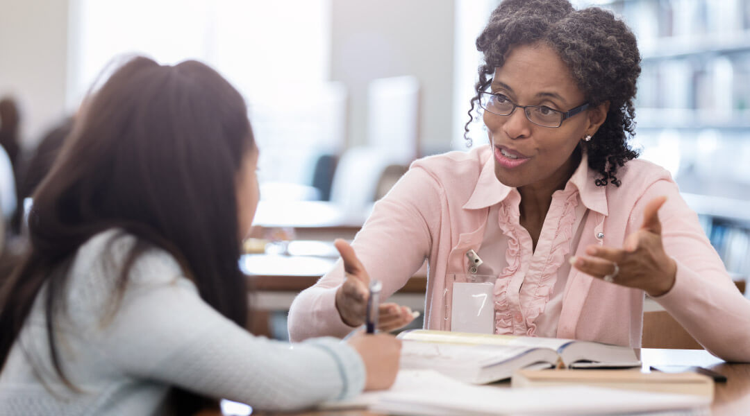 Adult and child in conversation at a table.
