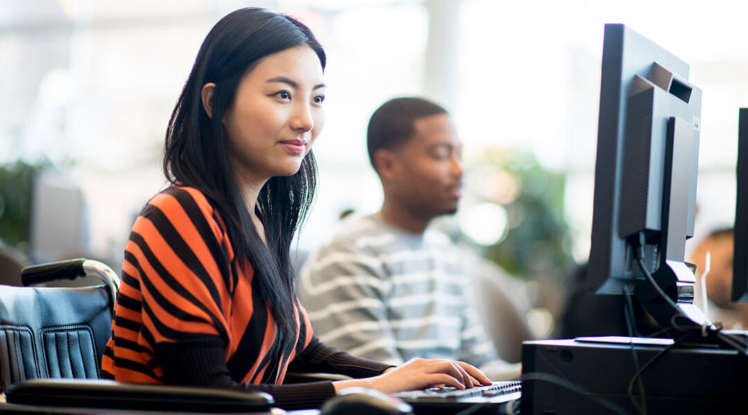 Adults sitting at library computers.