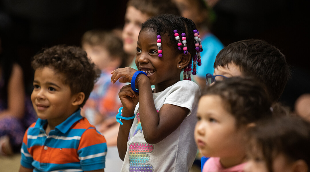 A group of toddlers listen to storytime.