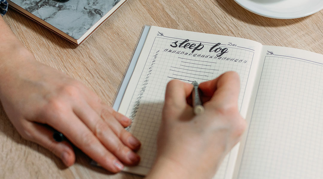 A person creates a bullet journal layout for a sleep log.