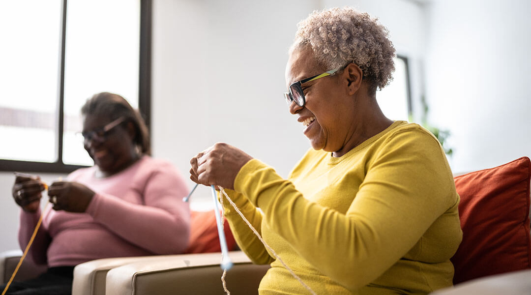 Group of senior friends women knitting at home