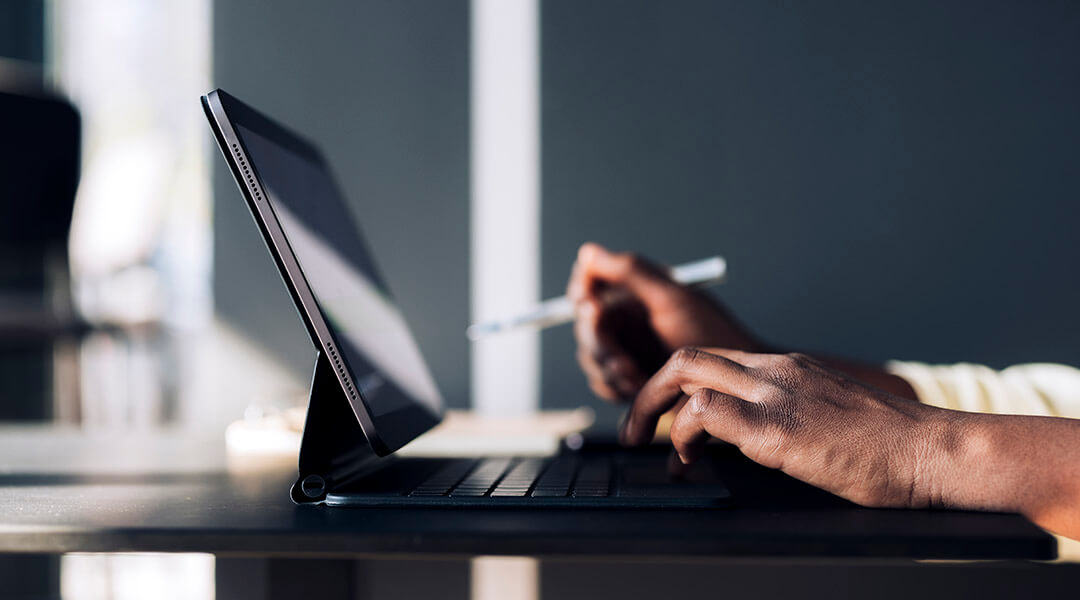 Close image of hands typing on the keyboard of a tablet computer.