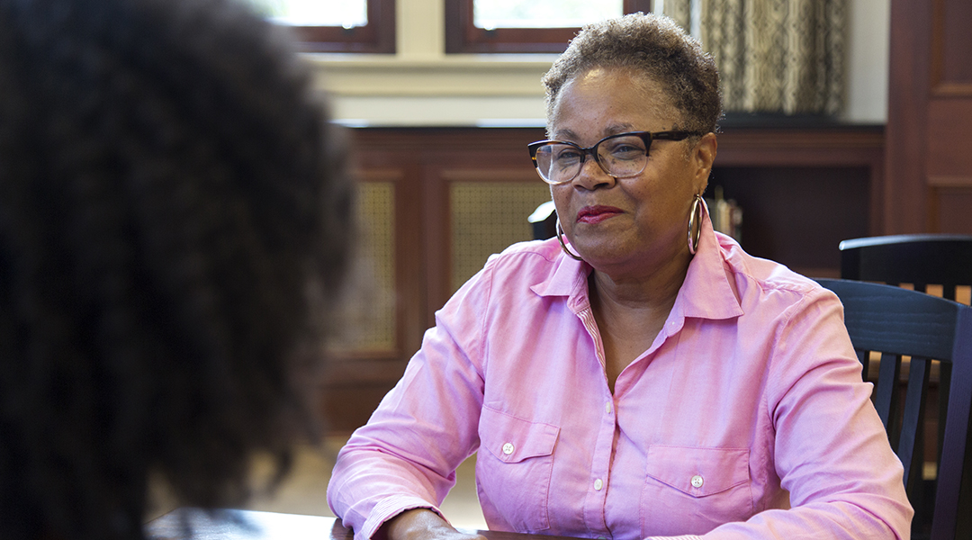 A smiling adult during a one-on-one meeting with a librarian.