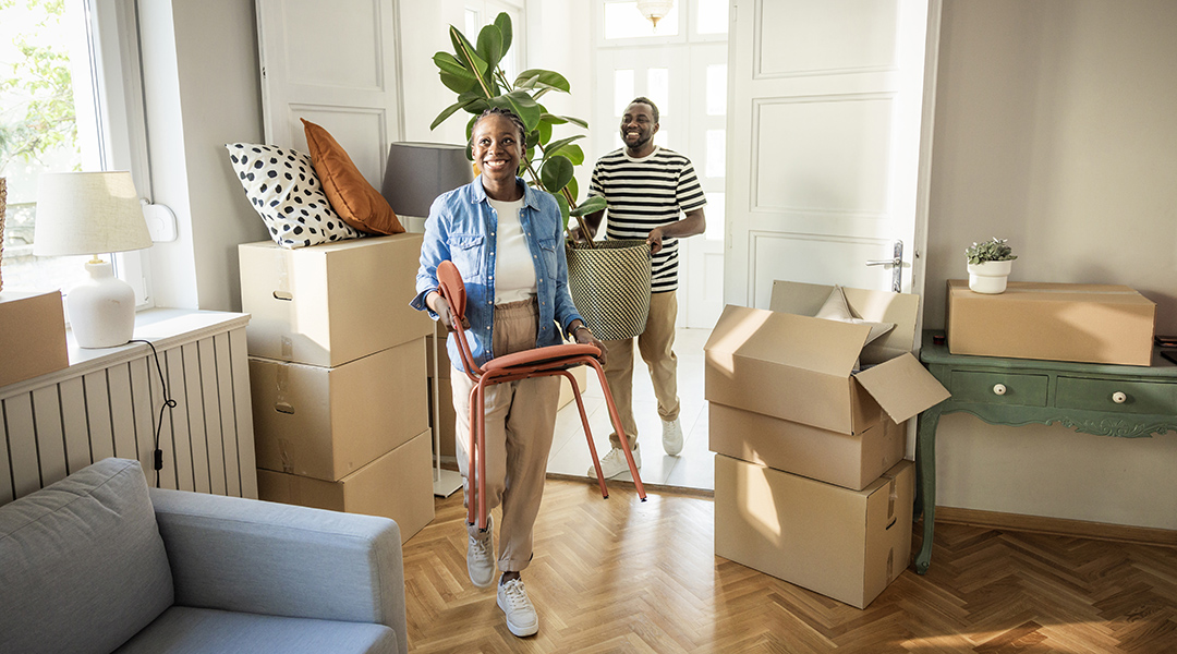Young couple moving in to their new home, unpacking boxes and enjoying the time together.