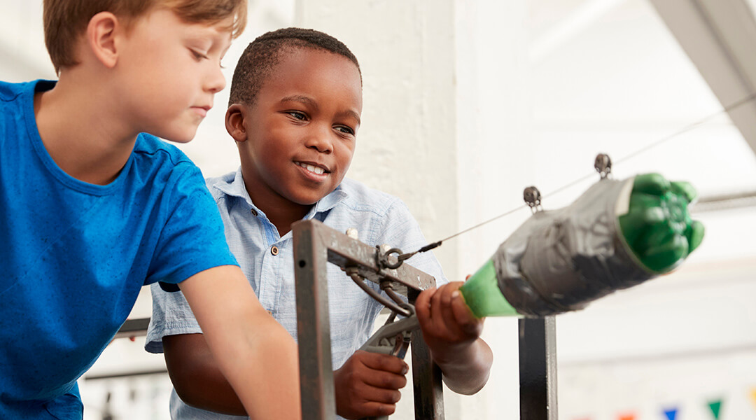 Two school children using air pressure rocket made out of a soda bottle.