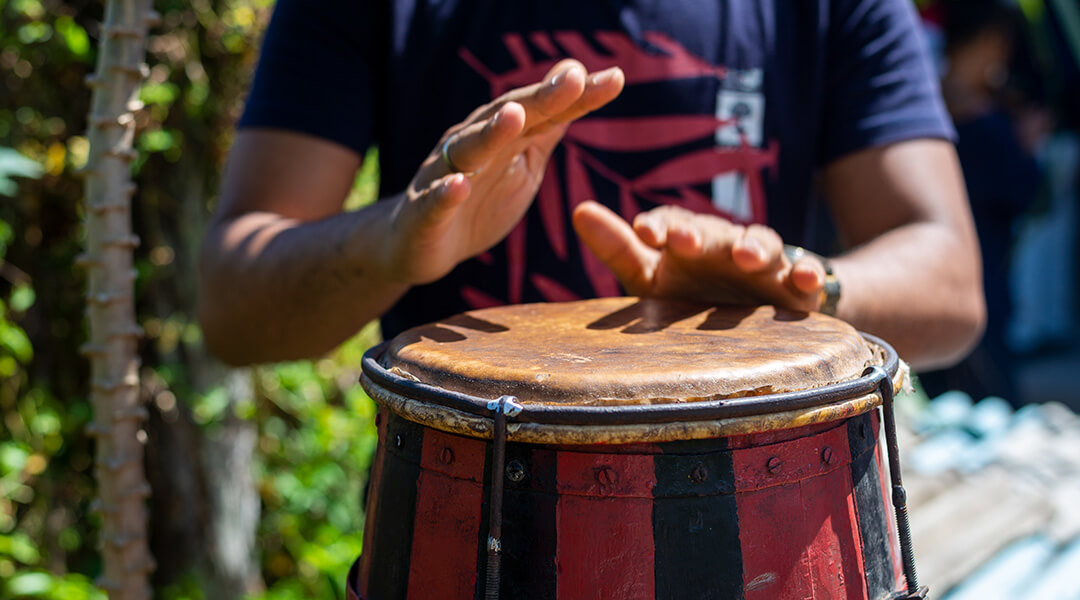Brazilian atabaque being played by the hands of a musician.