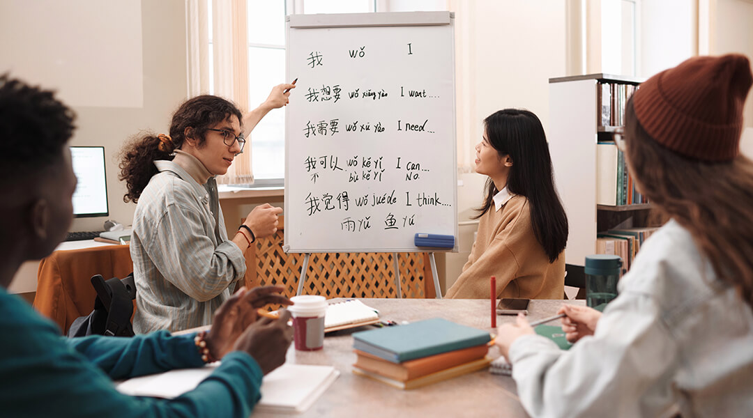 Side view portrait of an adult student answering questions during Chinese language class and pointing at whiteboard.