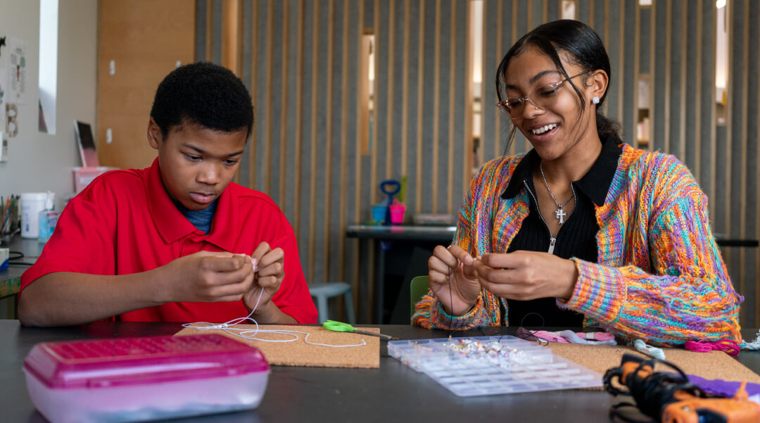 Teen girl and boy working on a project in the library