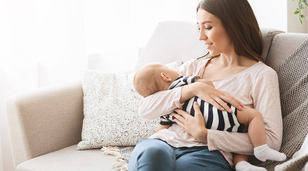 A parent cradles a baby on their lap.