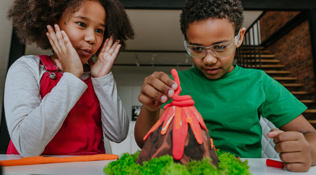 Two children craft a model volcano.