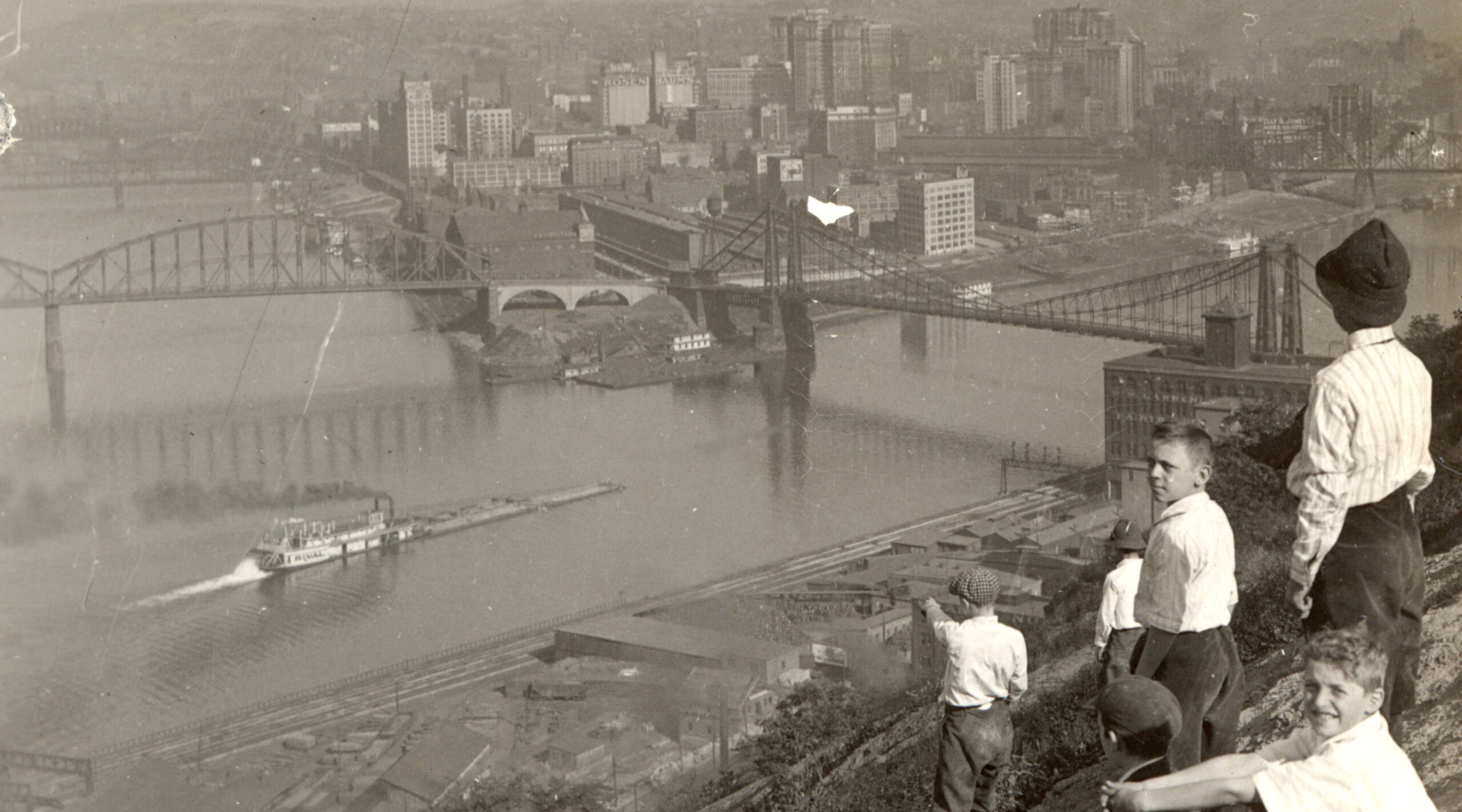 Historic black and white photo of a family looking over downtown Pittsburgh from Mount Washington.