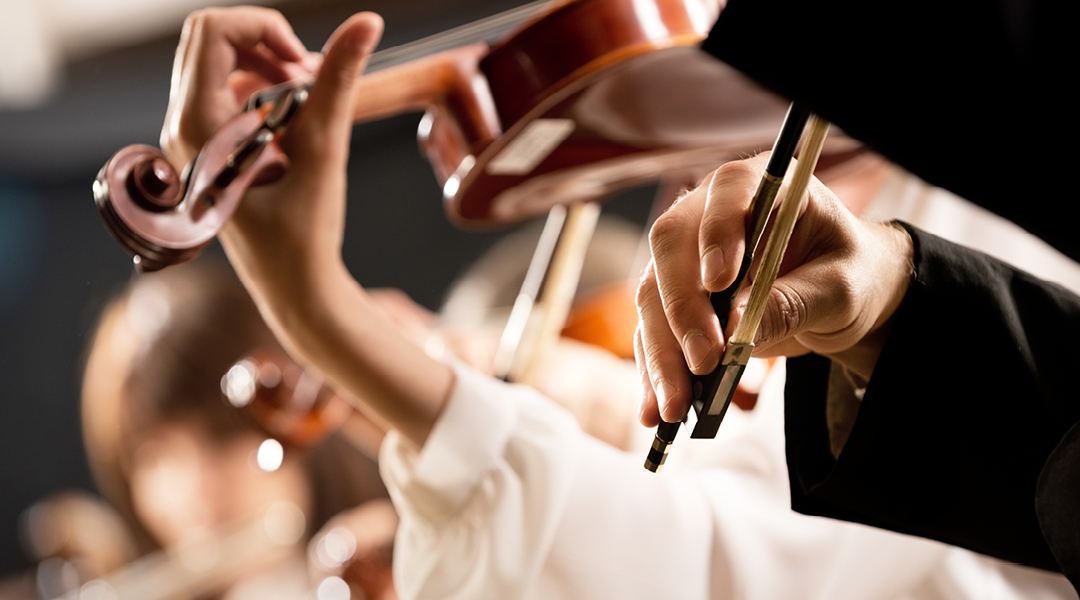 Closeup of hands playing violins