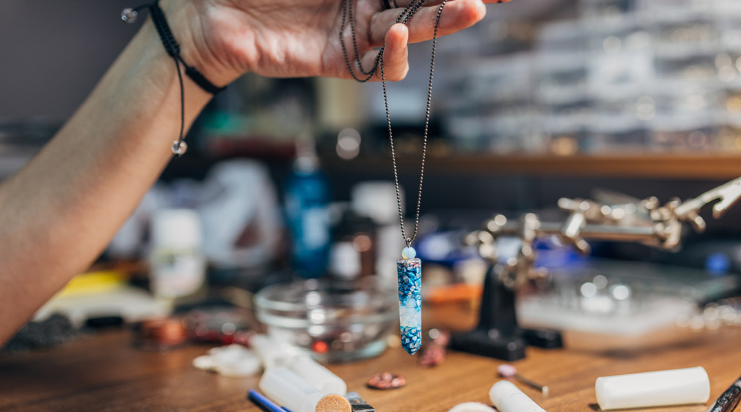 A crystal pendant hanging from a chain necklace.