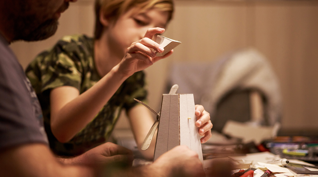 A tween builds a small model.