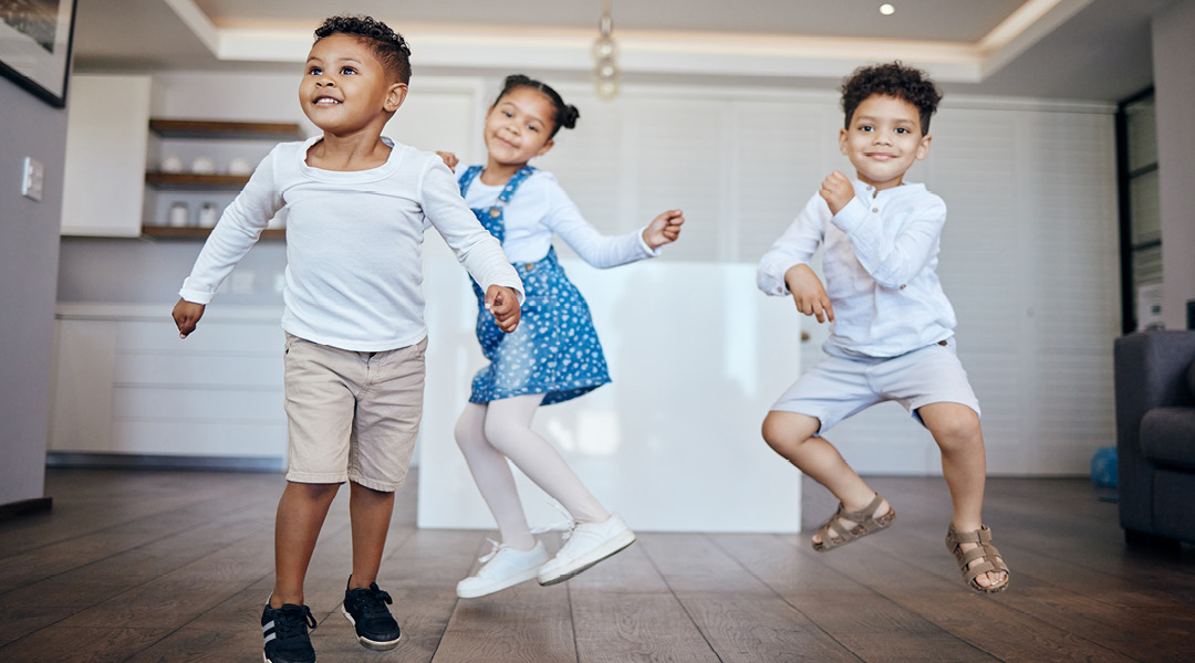 Three toddlers dance and jump inside.
