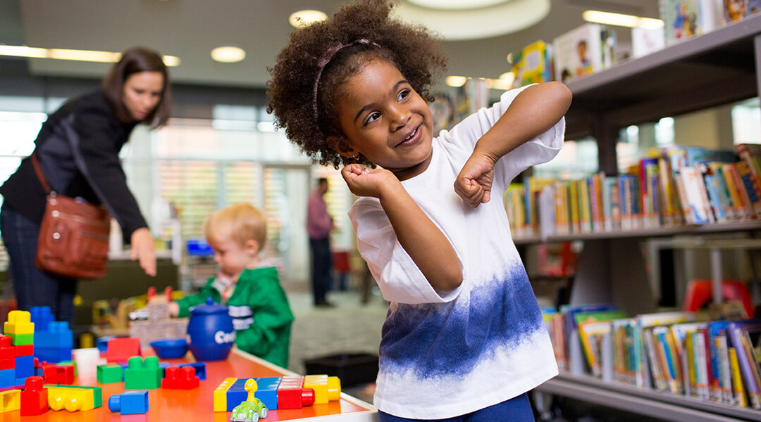 Little girl dancing in the library