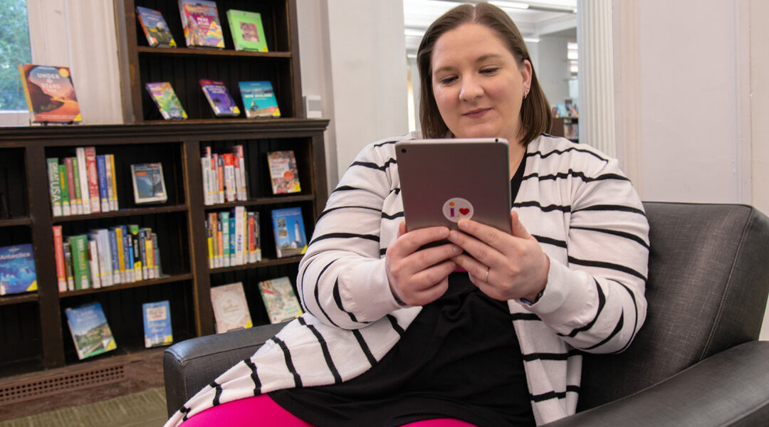 Brittany Mihalko Bozak reads on her kindle in the library.