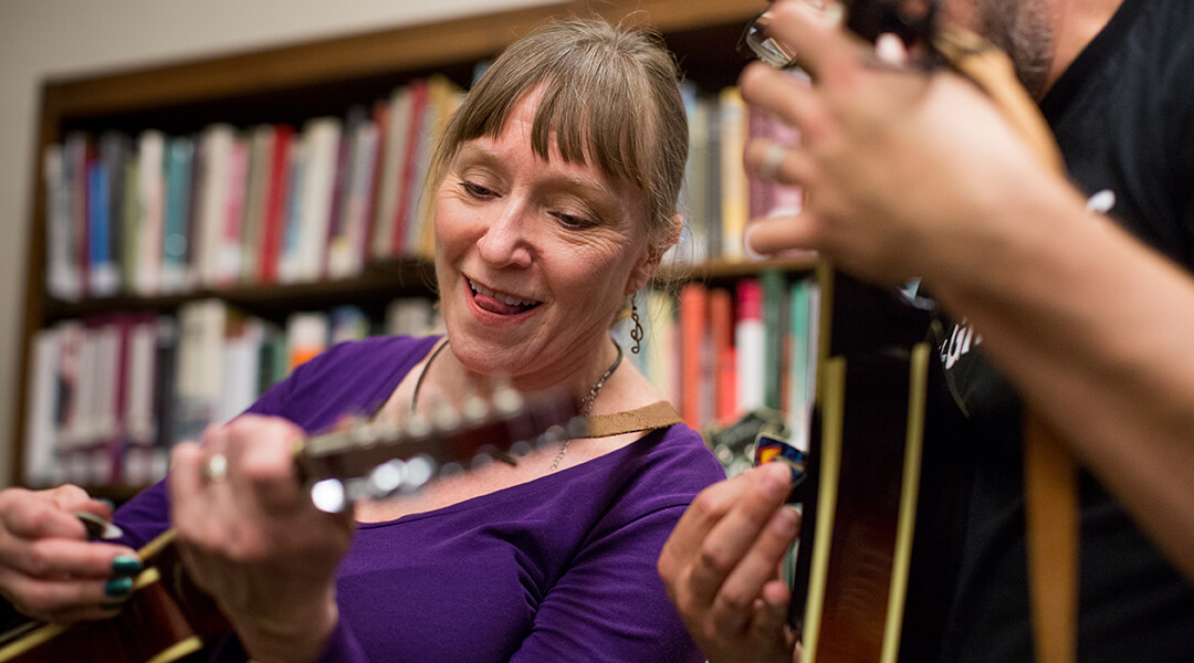 A woman plays guitar in the library